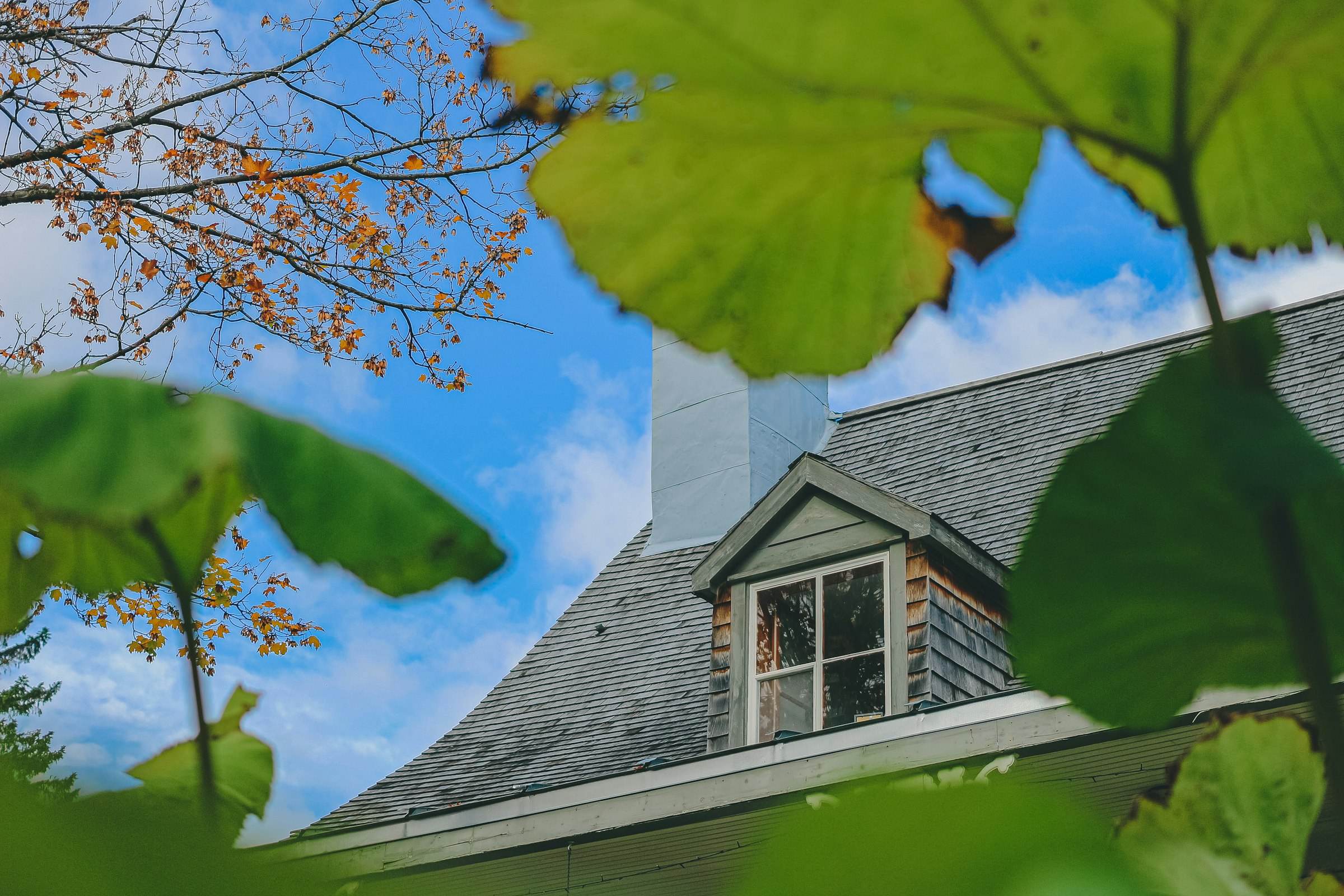 A roof with a dormer window and chimney, close detail